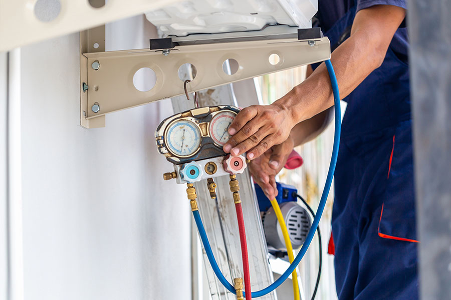 Technician adjusting a gauge on an HVAC unit