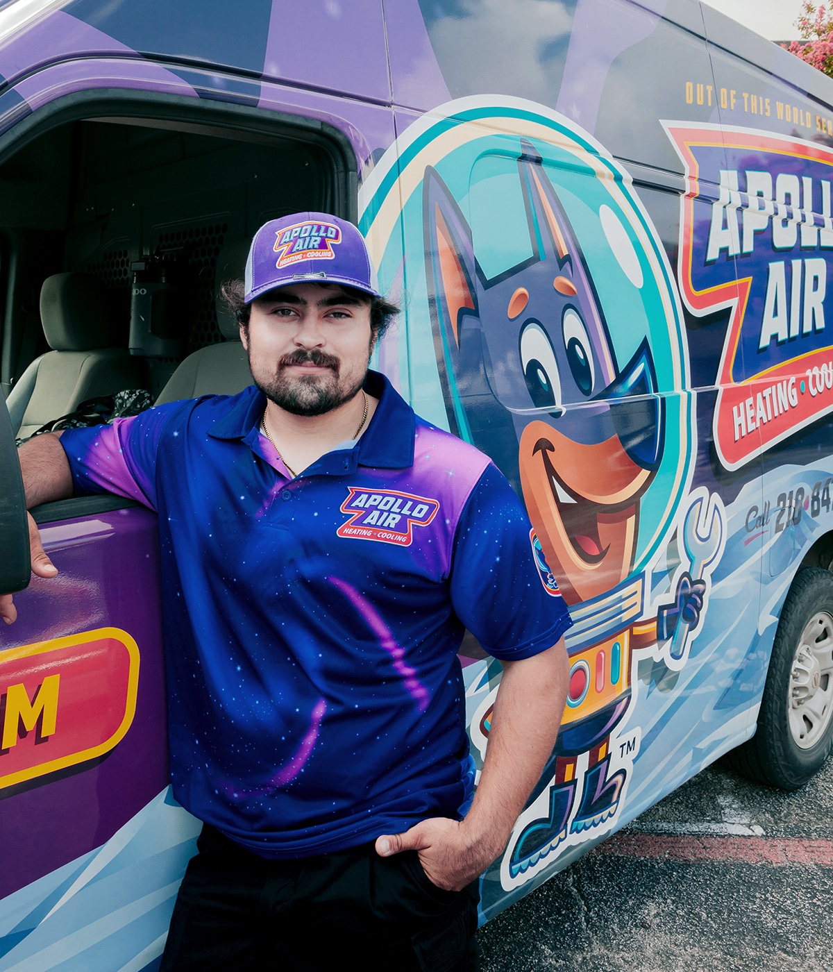 Apollo Air Heating and Cooling technician in branded uniform standing beside company service van in San Antonio